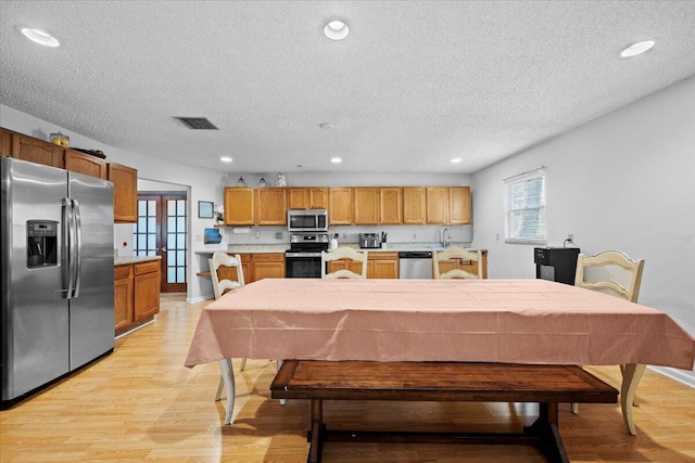 kitchen featuring light wood-style flooring, recessed lighting, visible vents, light countertops, and appliances with stainless steel finishes