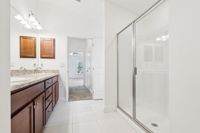 bathroom with a stall shower, tile patterned flooring, a sink, and double vanity