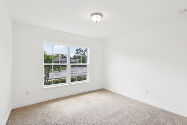 unfurnished room with carpet flooring and baseboards