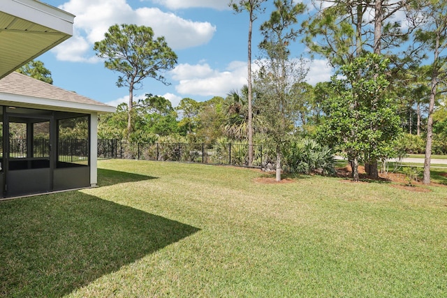 view of yard featuring a sunroom and fence