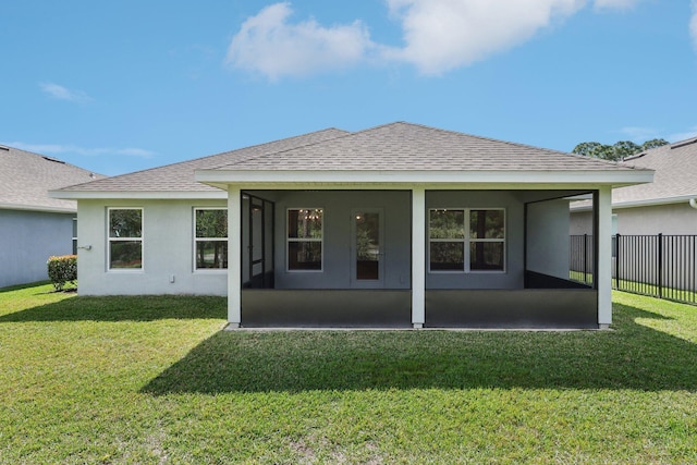 rear view of house featuring stucco siding, a shingled roof, fence, and a yard