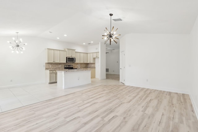 unfurnished living room featuring visible vents, light wood-style floors, vaulted ceiling, a chandelier, and baseboards