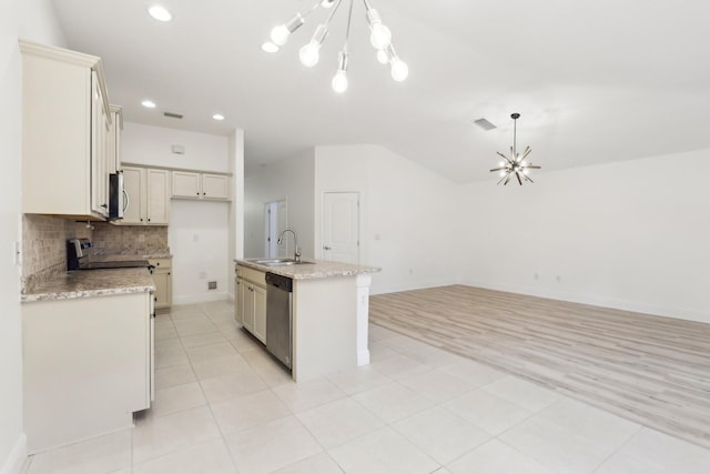 kitchen featuring a center island with sink, open floor plan, an inviting chandelier, stainless steel appliances, and a sink