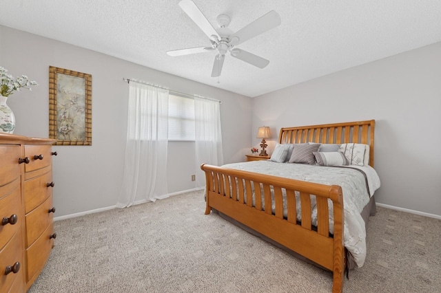 carpeted bedroom featuring ceiling fan, a textured ceiling, and baseboards