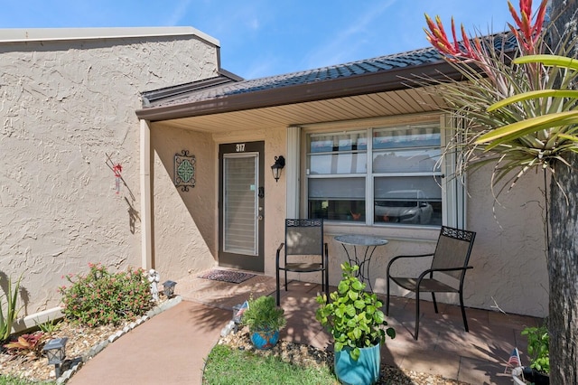 view of exterior entry with stucco siding