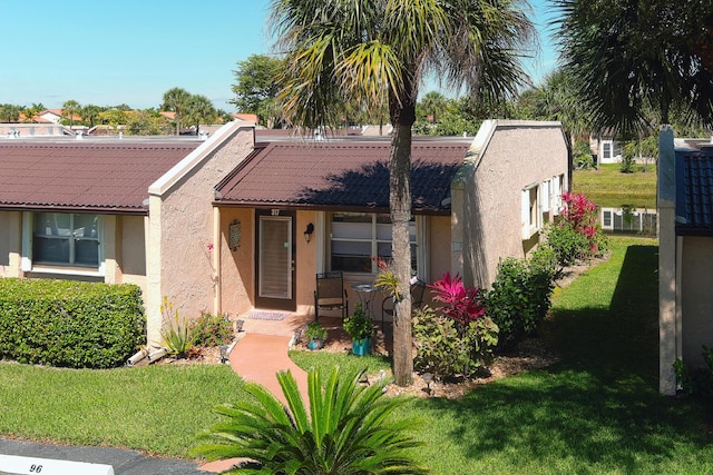 single story home with a tile roof, a front lawn, and stucco siding