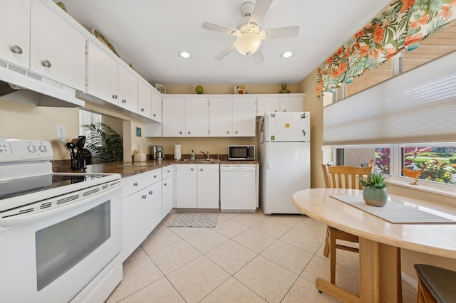 kitchen featuring white appliances, white cabinetry, a sink, and under cabinet range hood