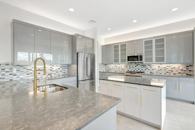 kitchen featuring appliances with stainless steel finishes, backsplash, modern cabinets, and gray cabinets