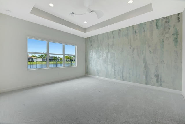 unfurnished room featuring visible vents, baseboards, a tray ceiling, carpet floors, and recessed lighting