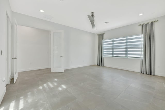 empty room featuring recessed lighting, visible vents, and baseboards