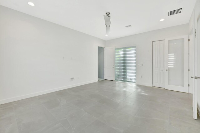 spare room with baseboards, visible vents, and recessed lighting