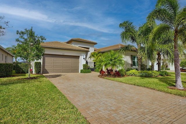 view of front of home with a garage, a front lawn, decorative driveway, and stucco siding