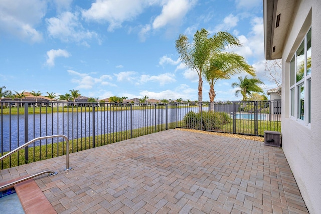 view of patio / terrace featuring a water view and fence