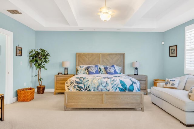 carpeted bedroom featuring a raised ceiling, visible vents, and baseboards