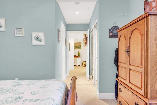 bedroom with light carpet and baseboards