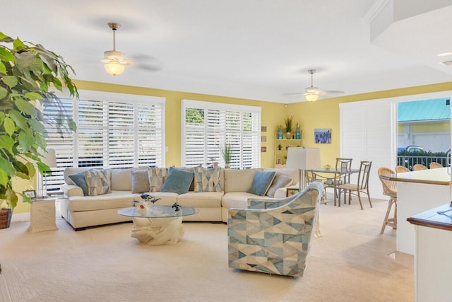 carpeted living area with a ceiling fan