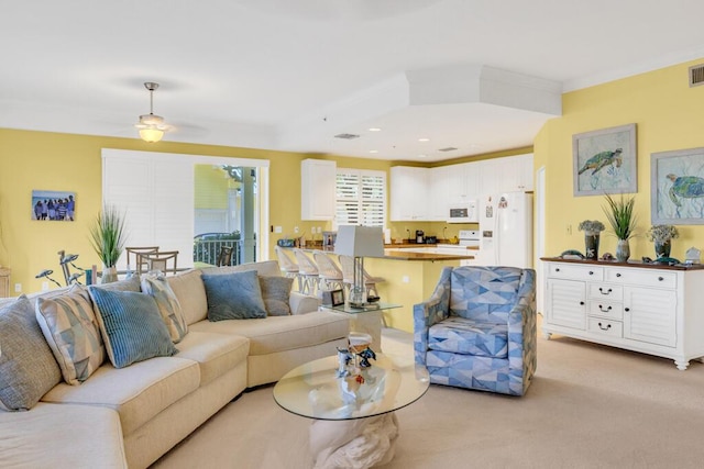 living area featuring light carpet, crown molding, and visible vents