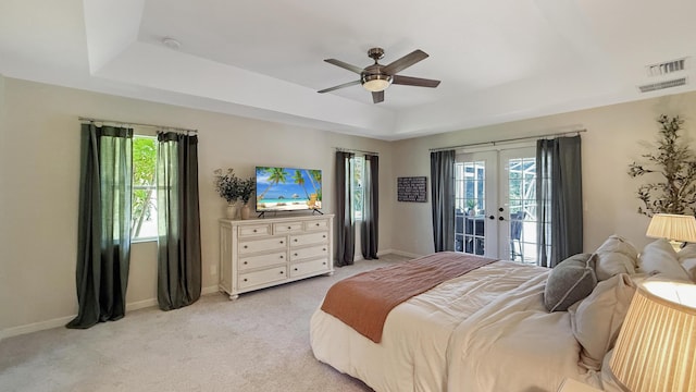 bedroom featuring light carpet, visible vents, access to exterior, a tray ceiling, and french doors