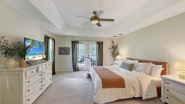 bedroom featuring french doors, a raised ceiling, light colored carpet, visible vents, and access to outside