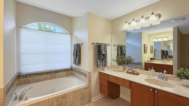 bathroom with tile patterned floors, visible vents, vanity, and a bath