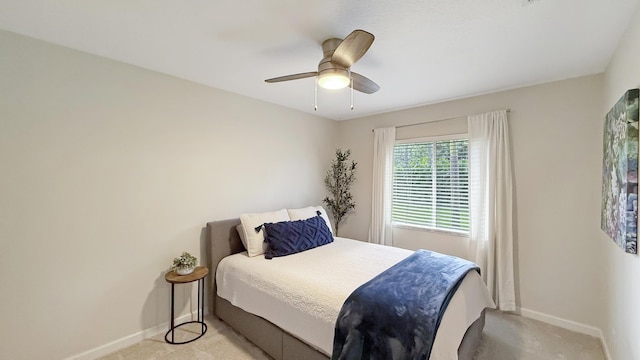 bedroom with a ceiling fan, light carpet, and baseboards