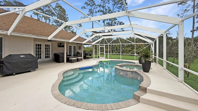 view of pool with glass enclosure, area for grilling, a pool with connected hot tub, french doors, and a patio area