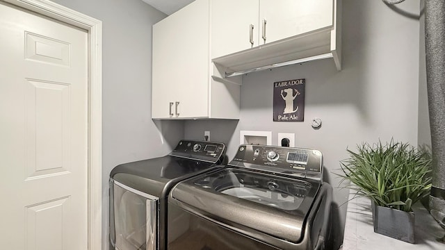 clothes washing area featuring cabinet space and washer and dryer