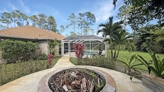 rear view of property with a fire pit, a patio area, a lanai, and stucco siding