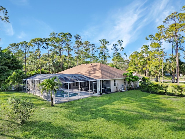 rear view of property with a yard, a lanai, an outdoor pool, and stucco siding