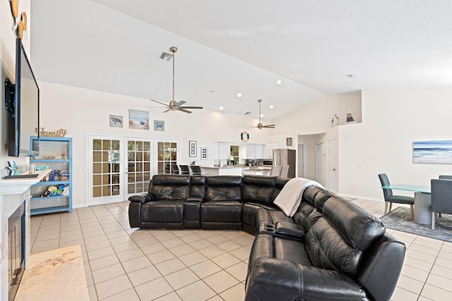 living area with light tile patterned floors, high vaulted ceiling, ceiling fan, baseboards, and french doors