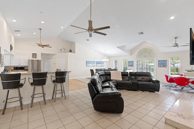 living area featuring ceiling fan with notable chandelier, recessed lighting, visible vents, and light tile patterned floors