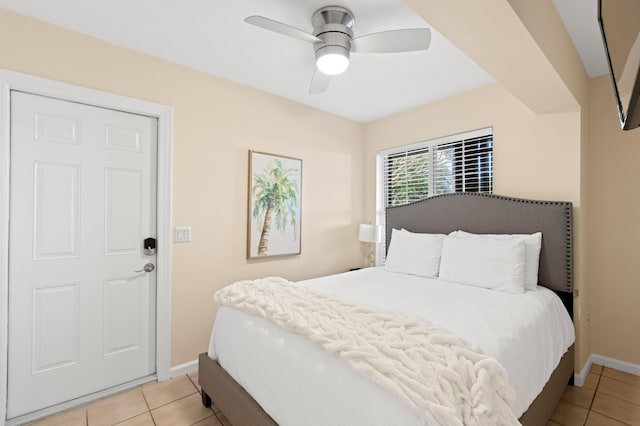 bedroom with light tile patterned floors, ceiling fan, and baseboards