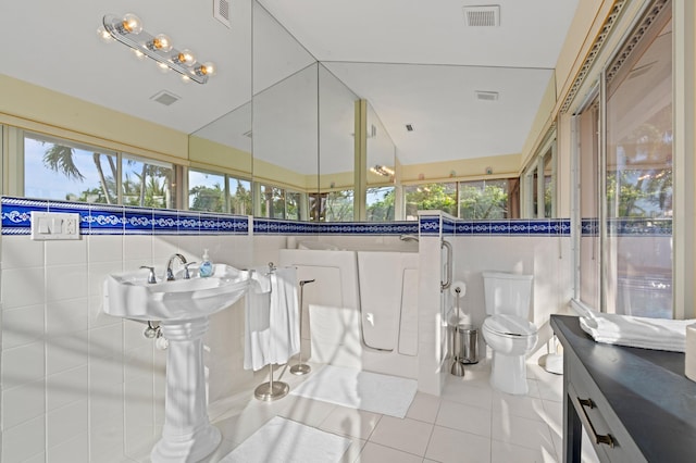 bathroom with toilet, visible vents, a wealth of natural light, and tile patterned floors