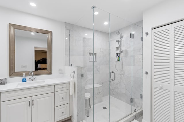 full bathroom with recessed lighting, a closet, vanity, and a marble finish shower