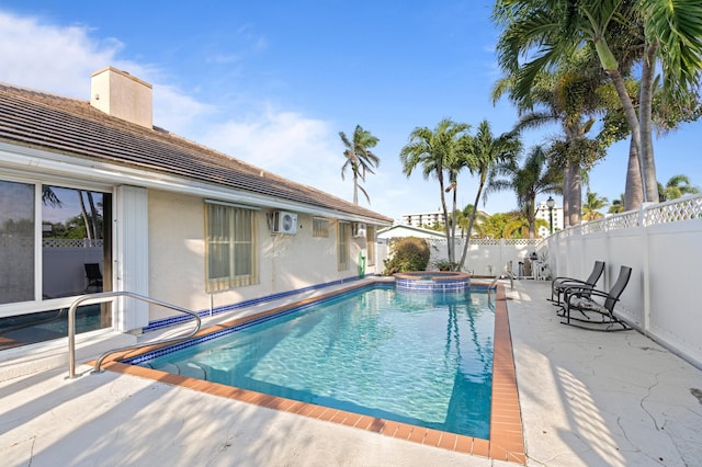 view of swimming pool with a patio area, a fenced backyard, and a pool with connected hot tub