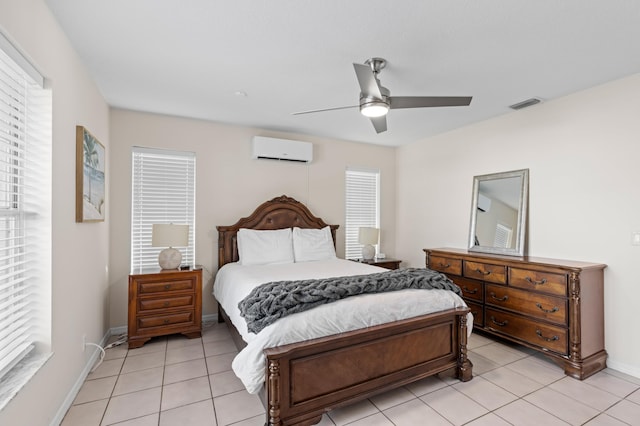 bedroom with light tile patterned floors, a wall unit AC, a ceiling fan, visible vents, and baseboards