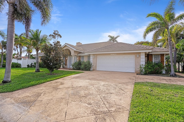 ranch-style home with stucco siding, an attached garage, a front yard, fence, and driveway