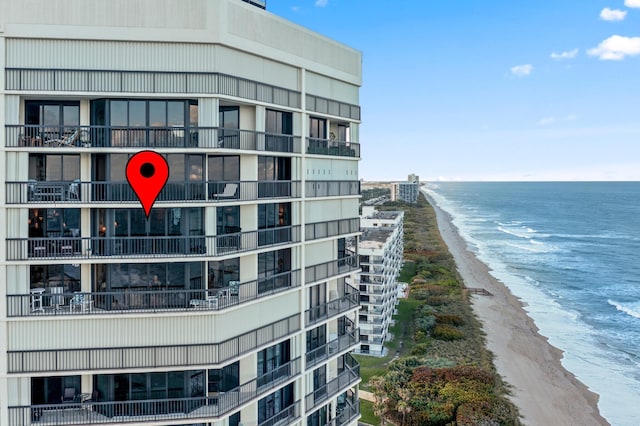 view of property with a water view and a view of the beach