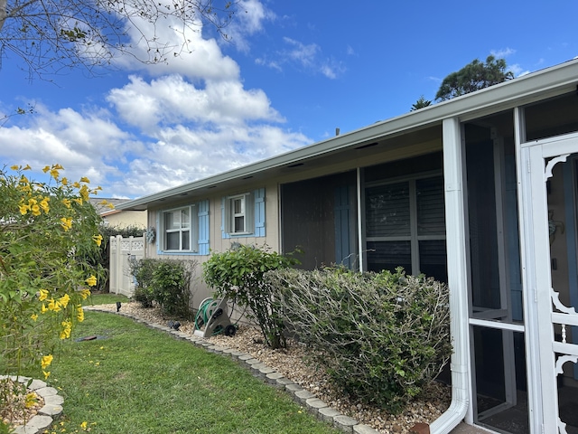 view of side of home with a yard