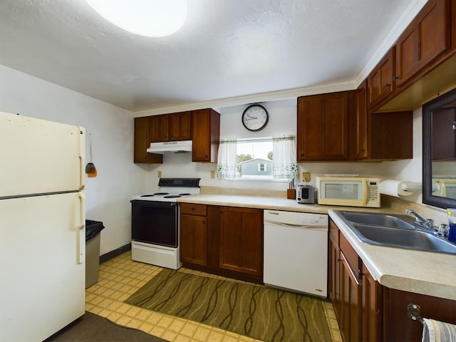 kitchen with white appliances, light floors, light countertops, under cabinet range hood, and a sink