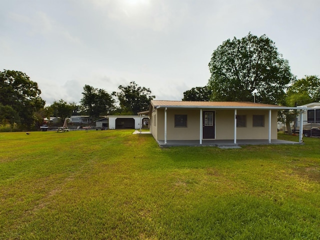 back of house with metal roof and a lawn