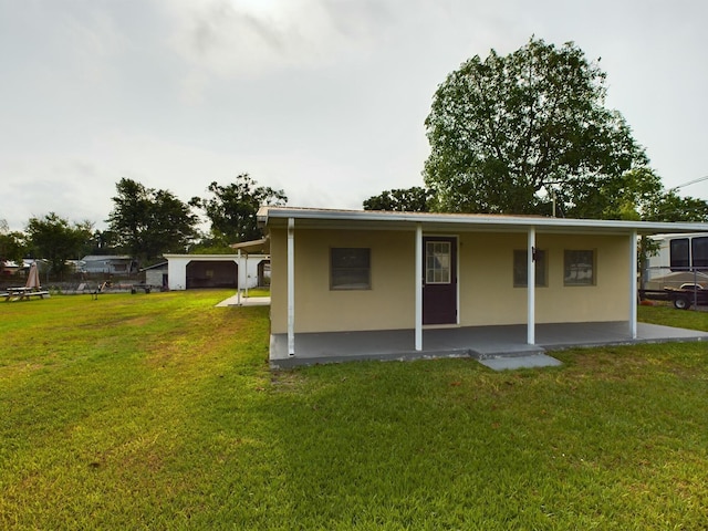 back of house featuring a lawn and stucco siding