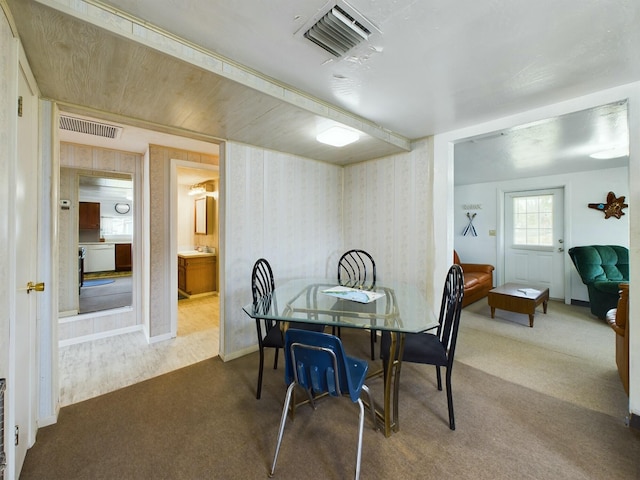 carpeted dining space with visible vents and wallpapered walls