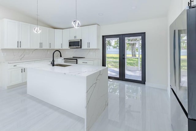 kitchen with lofted ceiling, decorative backsplash, appliances with stainless steel finishes, a sink, and light stone countertops