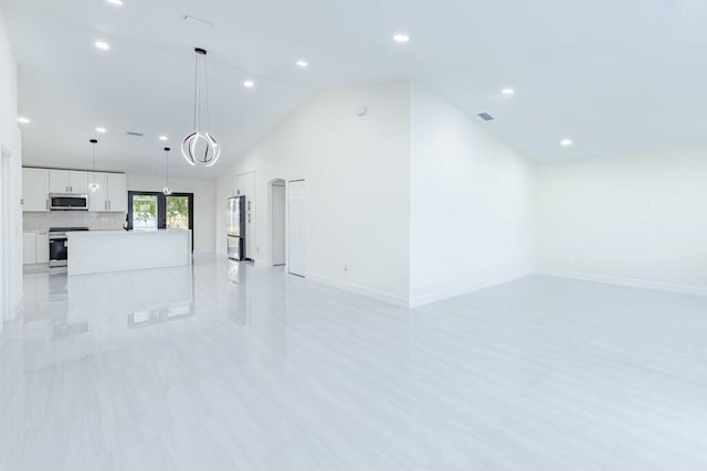 unfurnished living room with high vaulted ceiling, recessed lighting, visible vents, and baseboards