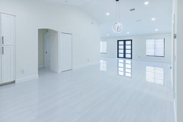 spare room featuring high vaulted ceiling, baseboards, arched walkways, and recessed lighting