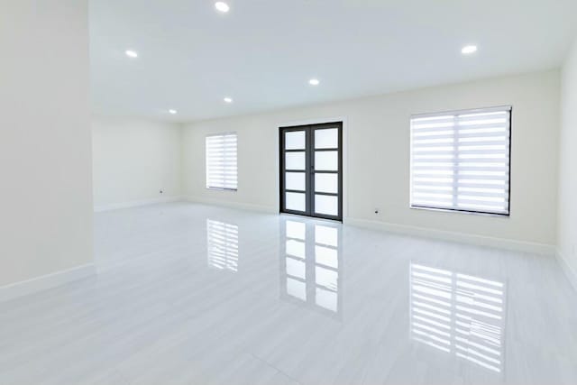 empty room with recessed lighting, french doors, and baseboards