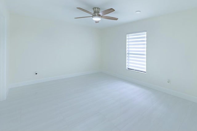 unfurnished room featuring ceiling fan and baseboards