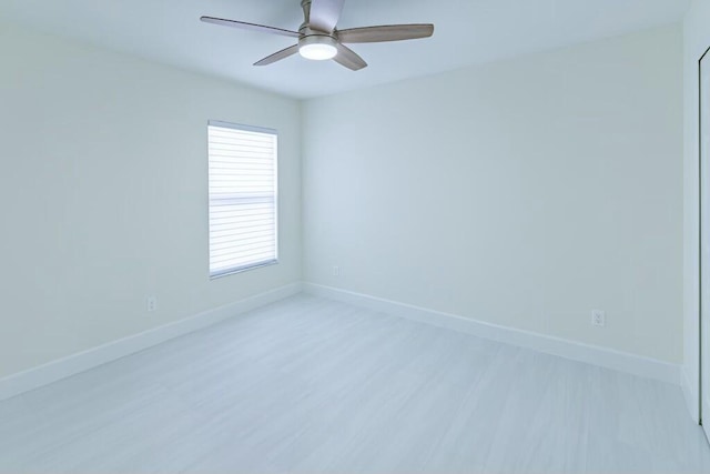 spare room with light wood-style floors, baseboards, and a ceiling fan