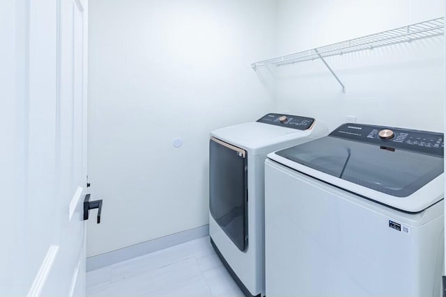 laundry room featuring laundry area, baseboards, and separate washer and dryer